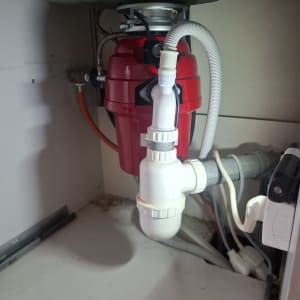 מתקן אינסטלציה מתחת לכיור עם צינורות וחיבורים