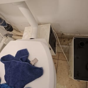אסלה עם מגבת כחולה וחלקי צנרת