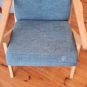 כיסא כחול עם כתמים על רצפת עץ