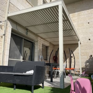 פרגולה מאלומיניום בחצר עם ריהוט גן