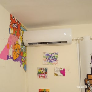 מזגן מותקן על קיר עם גרפיטי צבעוני