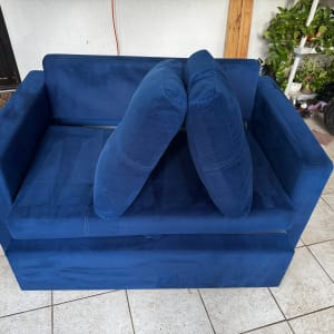 ספה כחולה עם כריות על רצפת אריחים