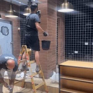 אנשים מנקים קירות עם דלי וסולם