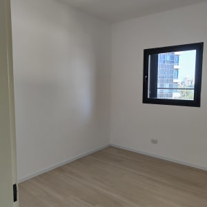 קירות לבנים חלקים בחדר ריק עם חלון