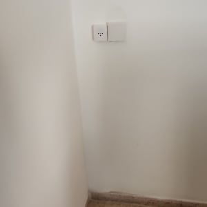 שקע חשמל על קיר לבן בפינת חדר