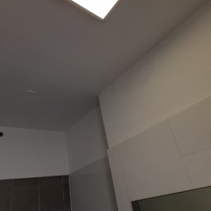 תאורת תקרה בחדר אמבטיה עם אריחים אפורים