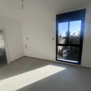 חדר ריק עם חלון גדול ורצפה נקייה