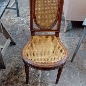 כיסא עץ עם מושב קלוע בסדנה או מחסן