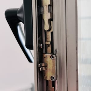 מנגנון נעילה של חלון או דלת עם ידית שחורה