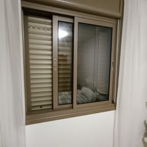 חלון עם תריסים חומים סגורים למחצה