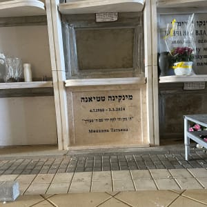 קבר עם כיתוב בעברית ותאריך, פרחים ליד