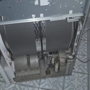 מכונת כביסה פתוחה עם כלים לתיקון על הרצפה