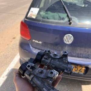 חלקי רכב מוחזקים מול רכב פולקסווגן כחול