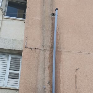 התקנת צינור אינסטלציה וניקוז חיצוני בגובה על חזית בניין