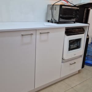 ארון מטבח לבן עם תנור ומיקרוגל על השיש