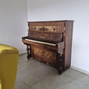 פסנתר עומד ליד כורסה צהובה בחדר ריק