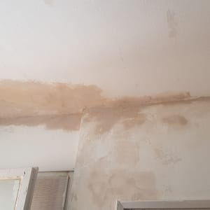 כתמי רטיבות על תקרה וקיר לבנים