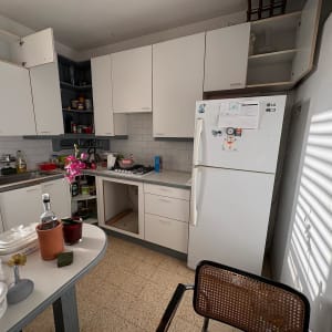 מטבח עם ארונות פתוחים ומקרר