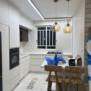 מטבח חדש עם ארונות לבנים ותאורה מודרנית