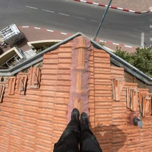 רעפים כתומים על גג עם צינור מתכת