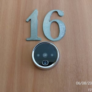 עינית דיגיטלית על דלת עץ עם מספר 16