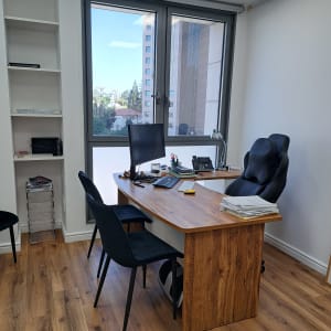 משרד עם שולחן עץ, כיסאות ומדפים ריקים