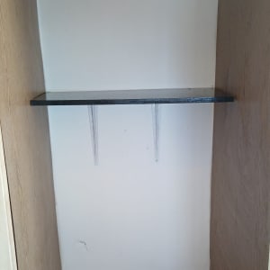 מדף מותקן בתוך ארון עם קיר לבן