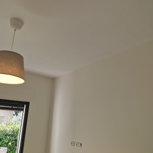 קיר צבוע בלבן עם שקעי חשמל חשופים