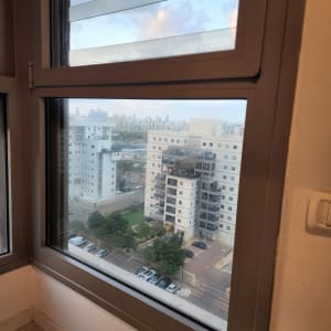 חלון זכוכית עם נוף של בניינים ועצים בחוץ