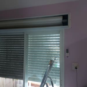 תריסים סגורים עם שלט על קיר ורוד