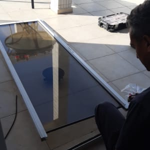 אדם עובד על תריסים עם מסגרת מתכת