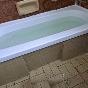 אמבטיה מלאה במים עם חיפוי קיר חום