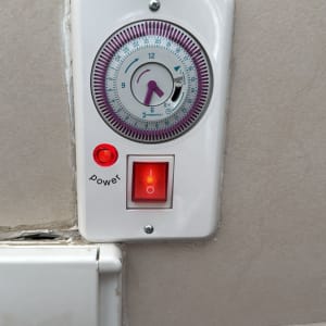 טיימר חשמלי עם מתג הפעלה על קיר