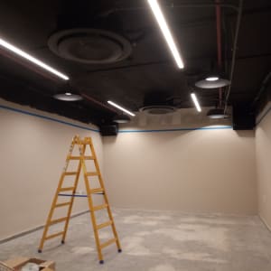 סולם צהוב בחדר עם קירות צבועים חלקית