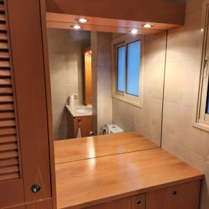 מראה וחלון בחדר אמבטיה עם ארון עץ