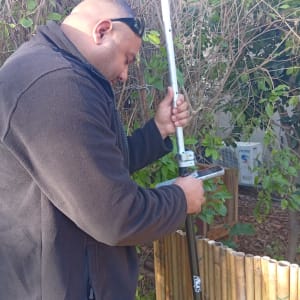 אדם משתמש בציוד מדידה בגינה