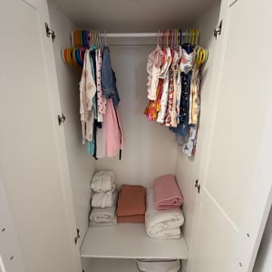 ארון בגדי ילדים מסודר ומאורגן עם בגדים תלויים ומצעים מקופלים