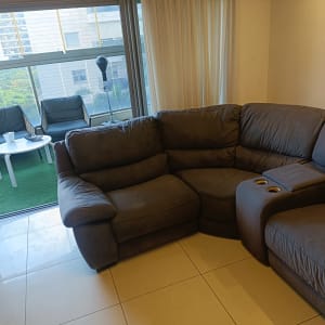 ספת בד פינתית כהה ומרווחת בסלון ביתי