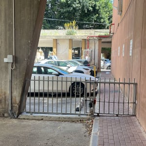 שער חשמלי בכניסה לחניון עם מכוניות חונות
