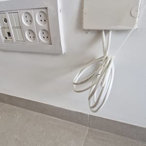 שקעי חשמל וכבלים על קיר לבן