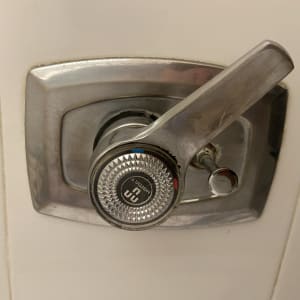 ידית ברז מתכתית עם כיתוב על רקע לבן