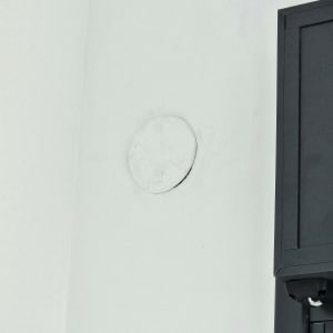 תמונה של קיר עם חור ותיבת חשמל