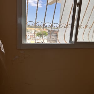 חלון עם סורגים וקיר עם סדקים