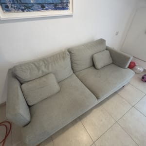 ספה אפורה עם כריות בחדר עם תמונה על הקיר