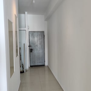 מסדרון עם קירות לבנים ודלת מתכת