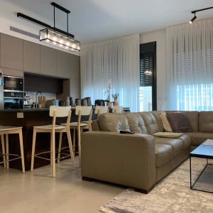 מטבח מודרני עם כסאות בר, ספה ושולחן סלון