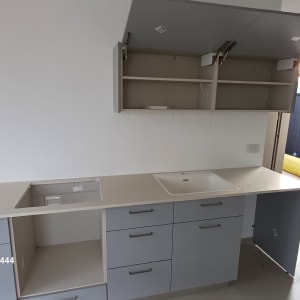 מטבח עם ארונות אפורים וכיור לבן