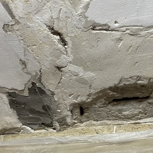 קיר עם טיח מתקלף וחורים, מוכן לתיקון