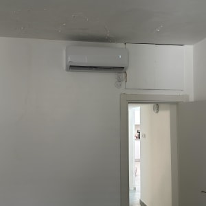 מזגן מותקן על קיר לבן בחדר פנימי