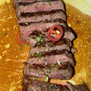 סטייק פרוס עם פלפל חריף ועשבי תיבול על צלחת